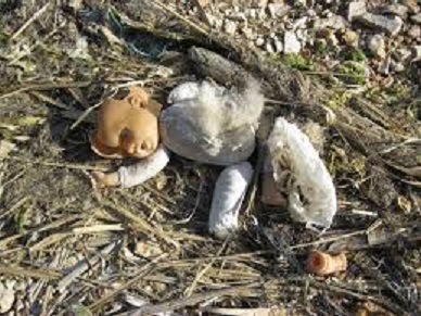 Broken, discarded doll