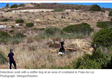 Detectives work with a sniffer dog at an area of scrubland in Praia da Luz. Photograph: Stringer/Reuters