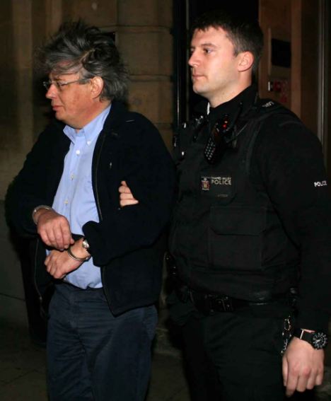 Arrested: Kevin Halligen being led away by a policeman in Oxford