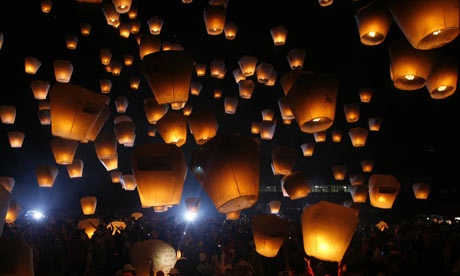 People release sky lanterns to celebrate the Chinese Sky Lantern festival. Photograph: NICKY LOH/REUTERS