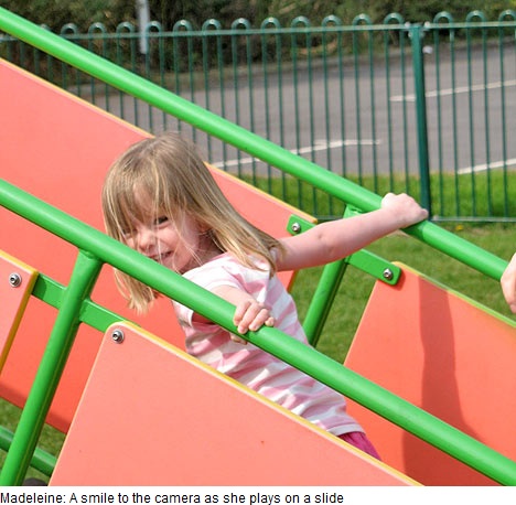 Madeleine: A smile to the camera as she plays on a slide