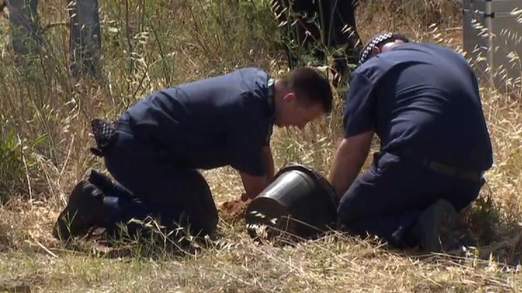 British police officers sifting through soil in the search area