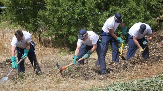 Officers search through scrubland close to where Madeleine disappeared