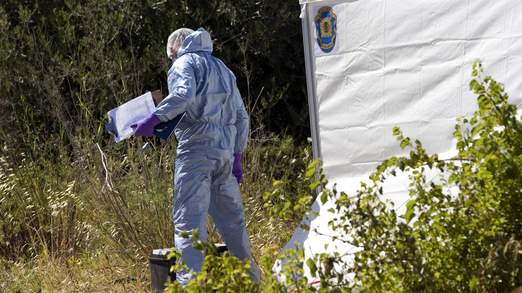 A Scotland Yard detective in a forensic suit during the first dig on June 2