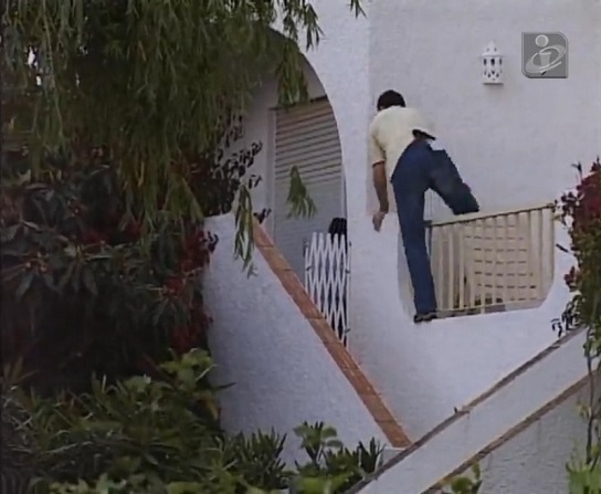 Screenshot from tvi24 video: Man climbing from the patio area of an Ocean Club apartment onto steps